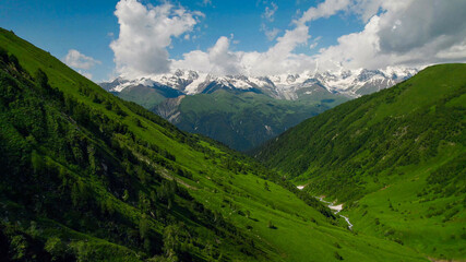 Naklejka premium Aerial view of a winding river cutting through a lush green mountain forest, showcasing nature, environment, and Earth Day concept