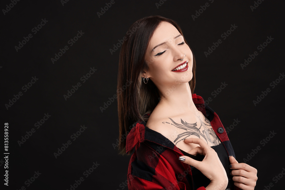 Canvas Prints Portrait of smiling tattooed woman on black background. Space for text