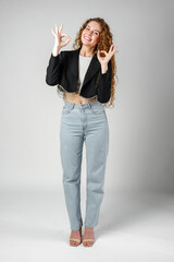 Young Woman Giving Ok Sign on gray background
