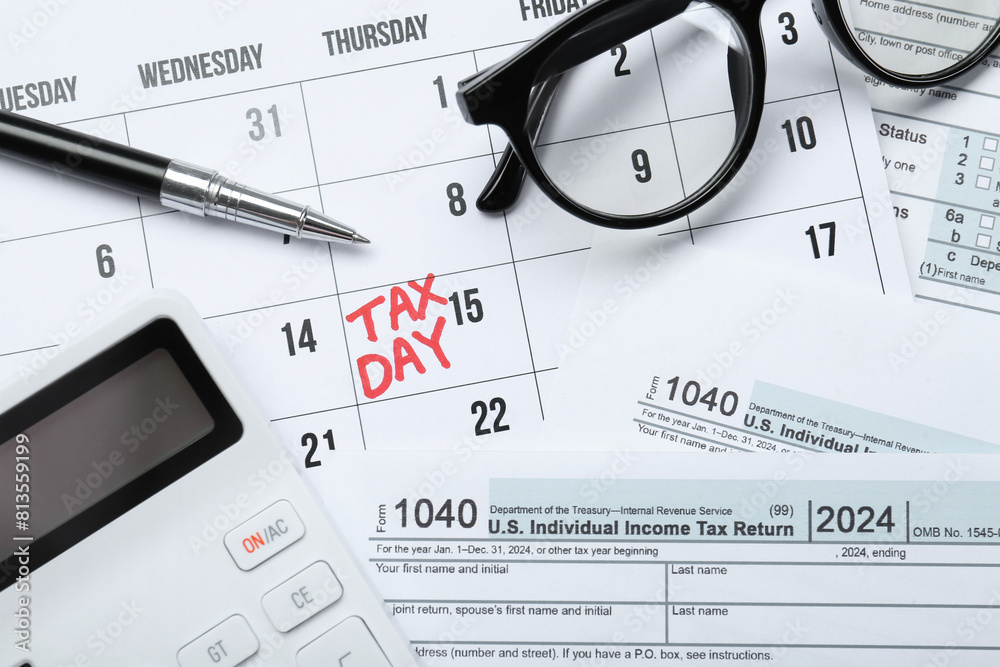 Wall mural calendar with date reminder about tax day, documents, glasses, pen and calculator, top view