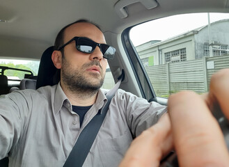 Uomo alla guida della propria automobile per le strade della città