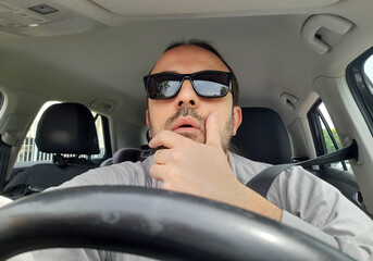 Uomo alla guida della propria automobile per le strade della città