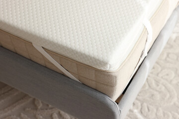 White memory foam mattress topper on grey bed