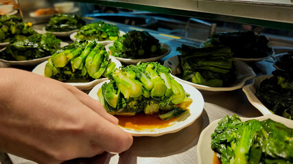 Plates of steamed bok choy with soy sauce in a Chinese restaurant, perfect for Asian cuisine themes...