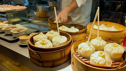 Assorted Chinese soup dumplings, xiaolongbao, in bamboo steamers at a dim sum restaurant, showcasing Asian cuisine, potentially for Chinese New Year celebrations