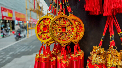 Traditional Chinese golden decorative knot ornaments on display at a street market, embodying...