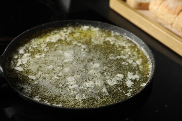 Melted butter in frying pan on table, closeup