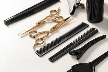Hairdresser tools. Different scissors and combs on white table, closeup