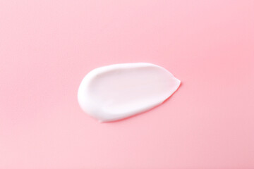 Sample of body care cream on pink background, top view