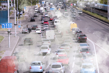 Environmental pollution. Air contaminated with fumes in city. Cars surrounded by exhaust on road