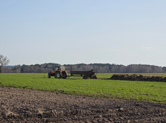 Rozrzucanie obornika traktorem wczesną wiosną © Joanna