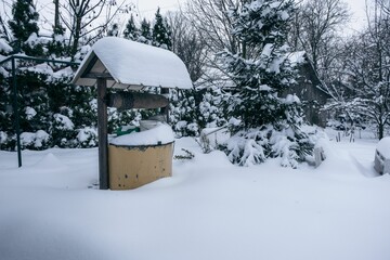Well covered with white fluffy snow in a backyard in winter