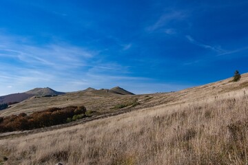 Fototapeta premium Beautiful view of the Bieszczady Mountains next to a dry hay field in Poland