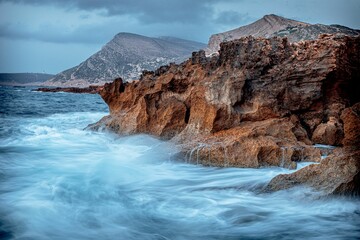 Coastal rocks and sea against the background of the cloudy sky.