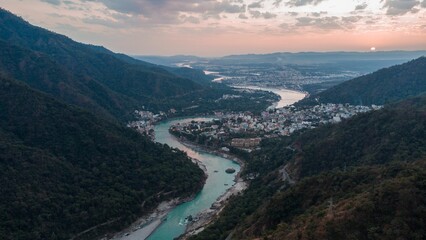 Aerial view of a river along Rishikesh valley and city with forested ,mountains © Wirestock