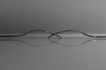 Closeup of two silver forks on a reflective background shot in grayscale