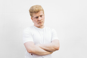 Monochrome: Portrait of an albino Latino man in white clothing against a white background.