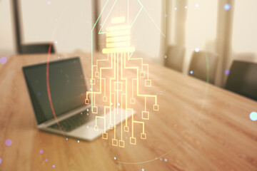 Double exposure of creative light bulb hologram with chip on laptop background, idea and...