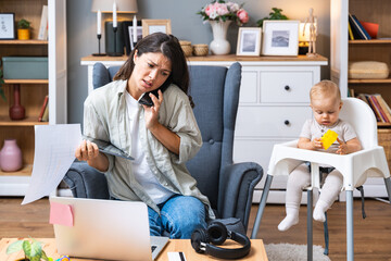 Multitasking mother. Young freelance business mom taking care of her child, young baby, and working...