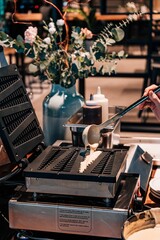 Cook making a waffle in a restaurant, a vertical shot