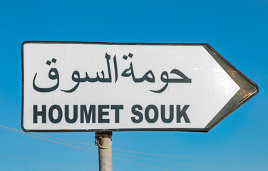 street sign to town of Houmet Souk in Djerba, Tusesia in european and arabic letter