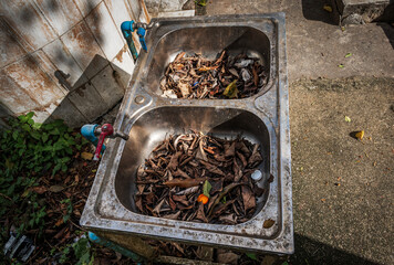 Old abandoned unused metal sinks and taps at outside of a Buddhist temple