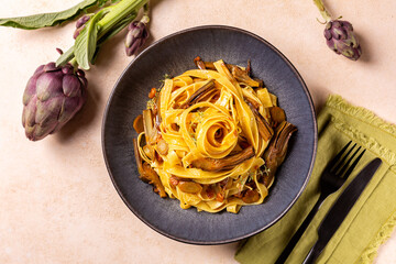Top view of a plate with artichokes pasta, fettucine and bacon,  seasoned with saffron and thyme....