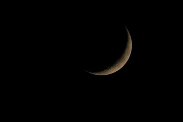 Waxing crescent phase of the moon on a dark sky background