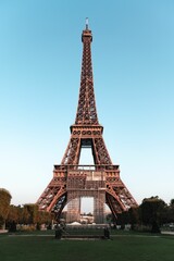 Fototapeta premium Vertical closeup of the Eifel tower and a park near it under the blue sky in Paris, France