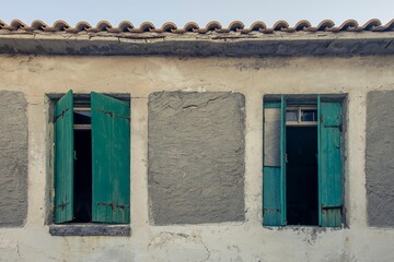 Old building with vintage wooden windows and cemented areas on the wall