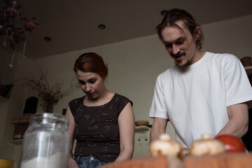 Real couple man and woman making food at home together