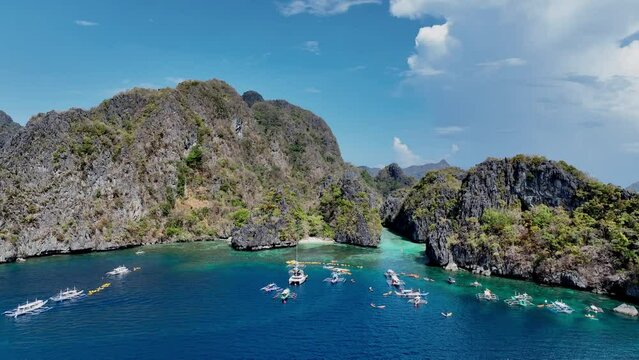 Aerial Top View of Bangka Boats as sand beach by a crystal clear water. Entalula island, Bacuit Bay, El Nido, Palawan, Philippines.	
