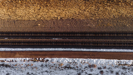 Railway tracks on a snowy surface, top view. Drone photo