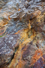Quartzite veins at the Fusafjorden and Samnagerfjord on the West-coast of Norway. The colors are include orange, ocher, brown and purple. In the middle of the photo it looks like there is face in it