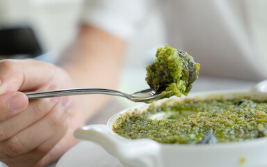 Closeup of eating the snail with herbs butter, Escargot. French traditional food. © Kajornsiri