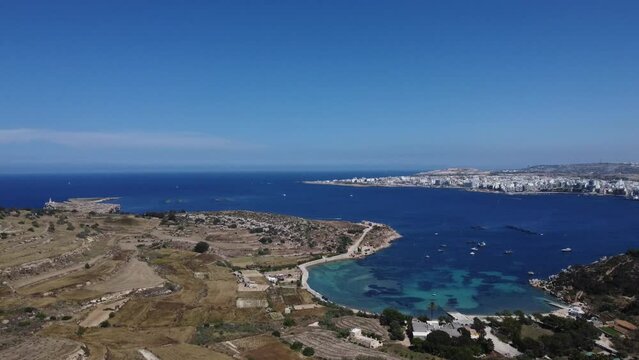 Mistra bay and Selmun peninsula agricultural terraced fields, secluded beach view from the Selmun palace. Aerial shot. St Pauls islands, Qawra and Bugibba in the distance. High quality 4k footage