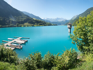 turquoise lake Lungernsee, with boardwalk and boats, observation tower