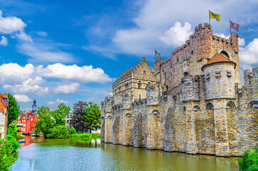 The Castle of the Counts Gravensteen medieval castle with stone walls on bank of Lieve water canal...