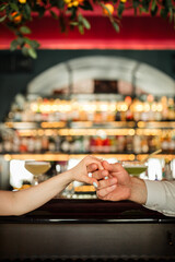 guy holding girl's hand against the background of a bar
