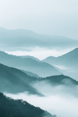 A tranquil view of the layers of mountain ridges disappearing into misty clouds, with their soft outlines and muted colors.