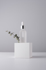 Serum bottle with pipette on gray background