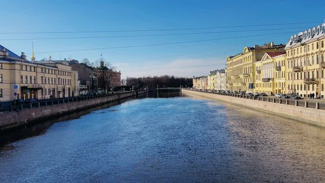 Russia, April 09, 2024: The channel in St. Petersburg in the spring. Bridges and historical buildings on the river embankment, people walking along the embankment. Reflections of houses in the water. 