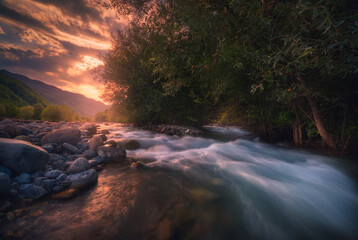 Beautiful sunrise over fast flowing mountain river