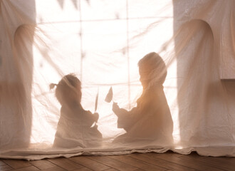 Children paying in the living room. Korean kids staged a shadow theater. Brother and sister are...