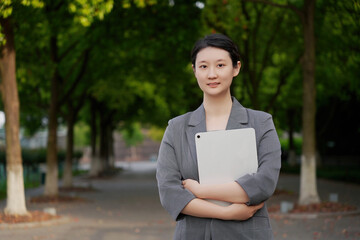 Confident Young Businesswoman with Tablet in Park