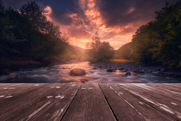Magical sunrise over fast flowing mountain river with empty wooden batten bridge. Natural template...