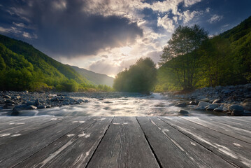 fast flowing mountain river with empty wooden batten bridge. Natural template landscape