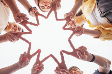 Teenagers hands making a star. Male and female palms in circle. Five funny laughing teens building...