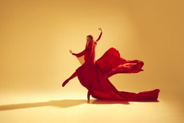 Lyrics of movement, Elegant woman, female dancer in red flowing dress with face covered dancing...