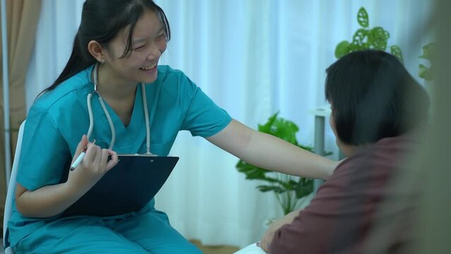 Asian female doctor Keep notes on caring for a patient with Down Syndrome at home.